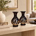 Noir Bloom black and gold vase pair styled on a travertine console