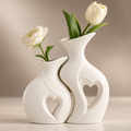 Close detail of the Amora white ceramic vase pair with sculptural heart cut-outs