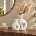 Amora nested white ceramic vases styled with dried stems on a walnut entry console