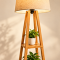 Close view of the beige natural-fibre shade and wooden tripod shelf details