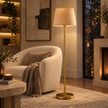 VIRAAM Aurelia brass floor lamp beside a cream lounge chair