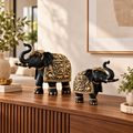Black and gold Aurum Gaja elephant pair styled on a premium living-room console
