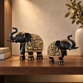 Aurum Gaja elephant statue pair displayed on a warm walnut shelf