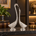 Oxidised silver swan figurines in a premium office interior
