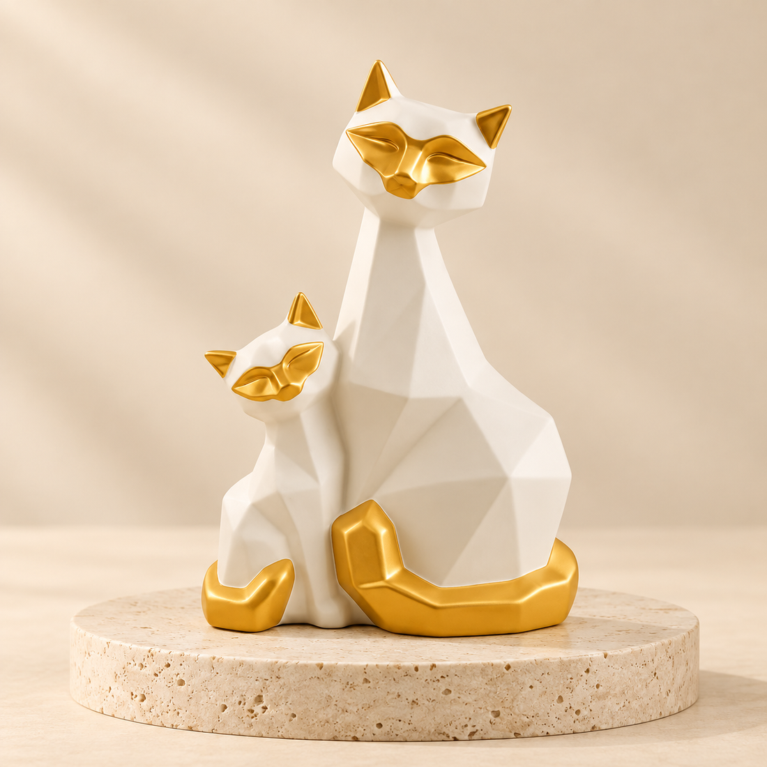 White and gold geometric porcelain cat figurine pair on a travertine pedestal