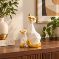 White and gold geometric cat figurine pair styled on a walnut console