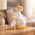 White and gold cat duo showpiece on an oak bedside table