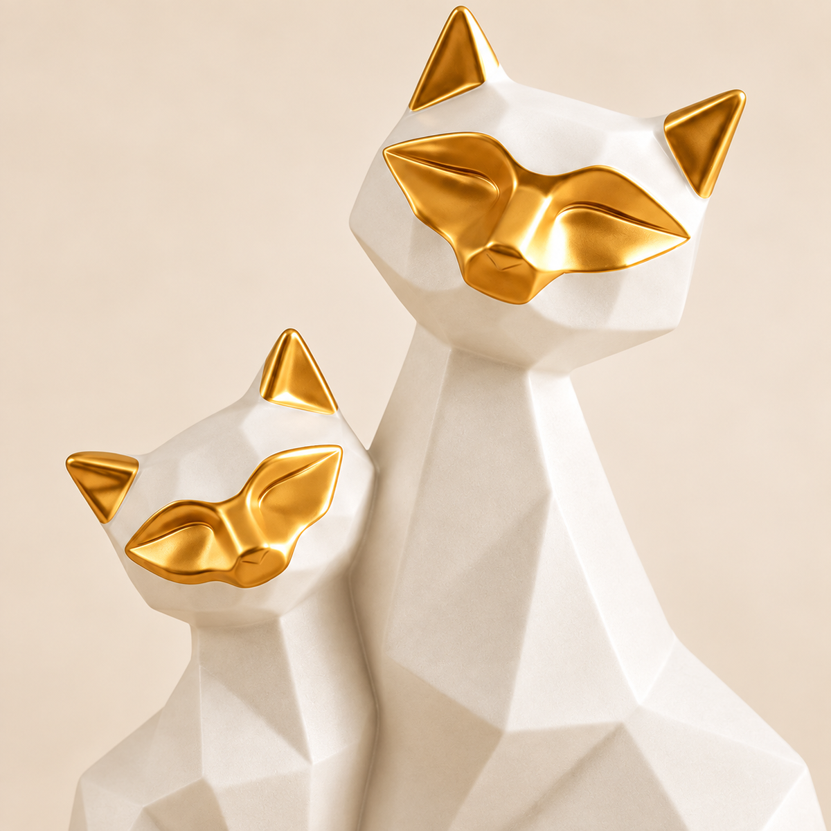 Close-up of gold facial detailing and faceted white porcelain on the cat duo