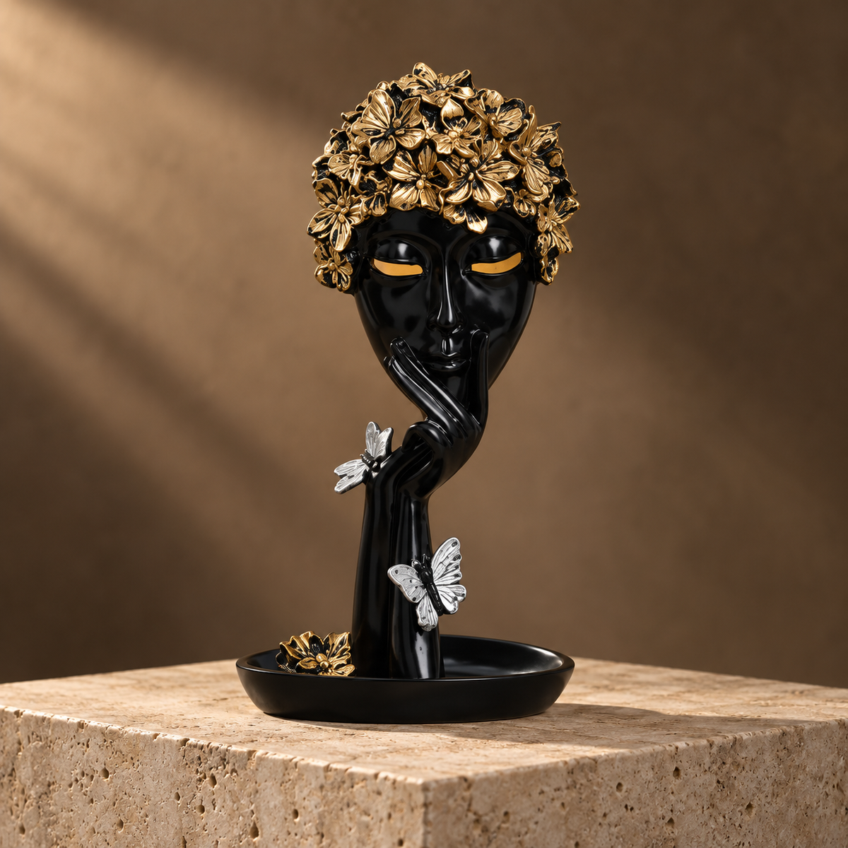 Black face sculpture with gold floral crown and silver butterflies