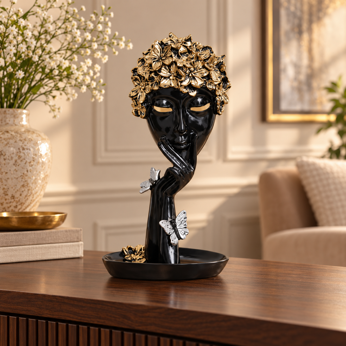 Black and gold woman face showpiece styled on a walnut console