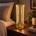 Gold LED touch lamp glowing on a bedside table